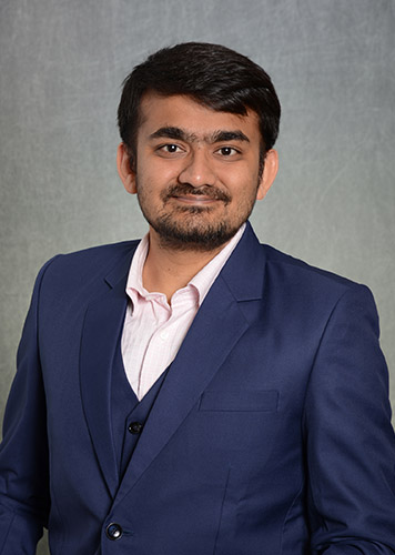 A headshot of Sanket Mehta in front of a grey background.